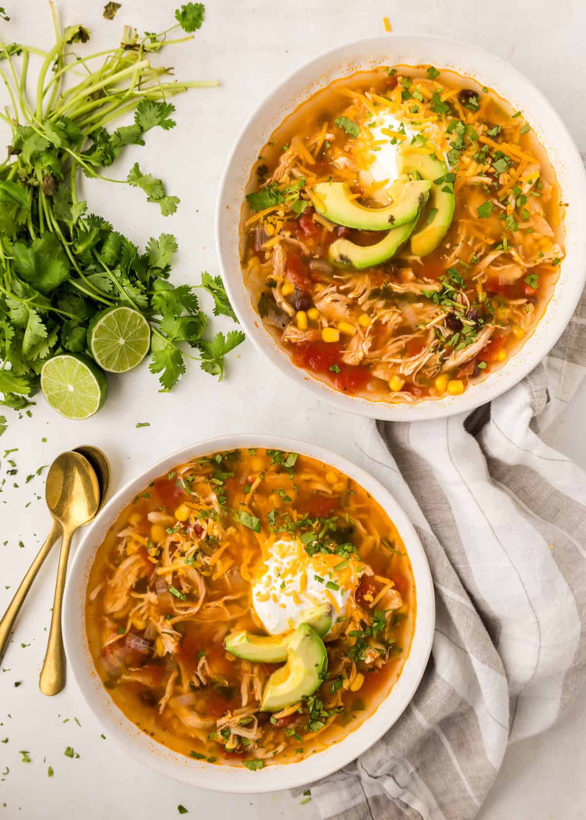 chicken taco soup served with dollop of sour cream and avocado slices
