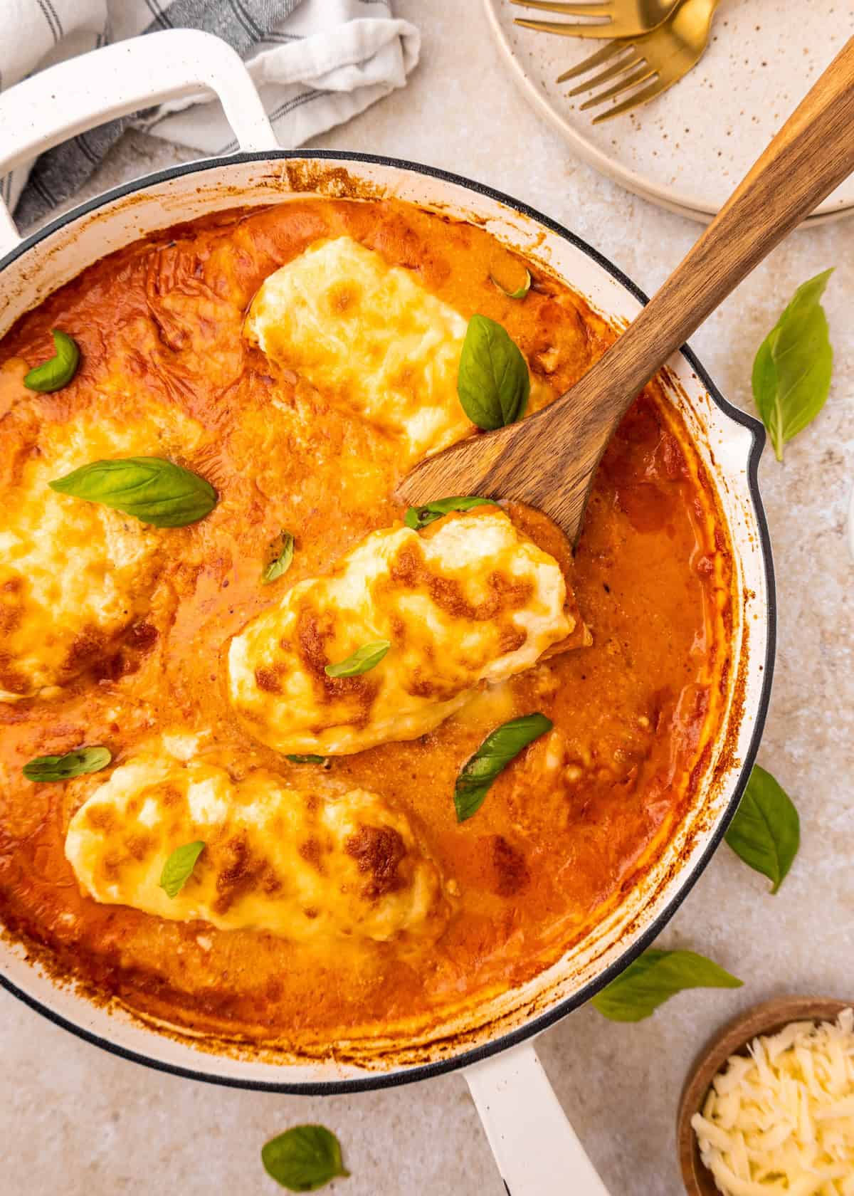 Chicken al forno in creamy tomato sauce, topped with melted cheese and fresh basil.