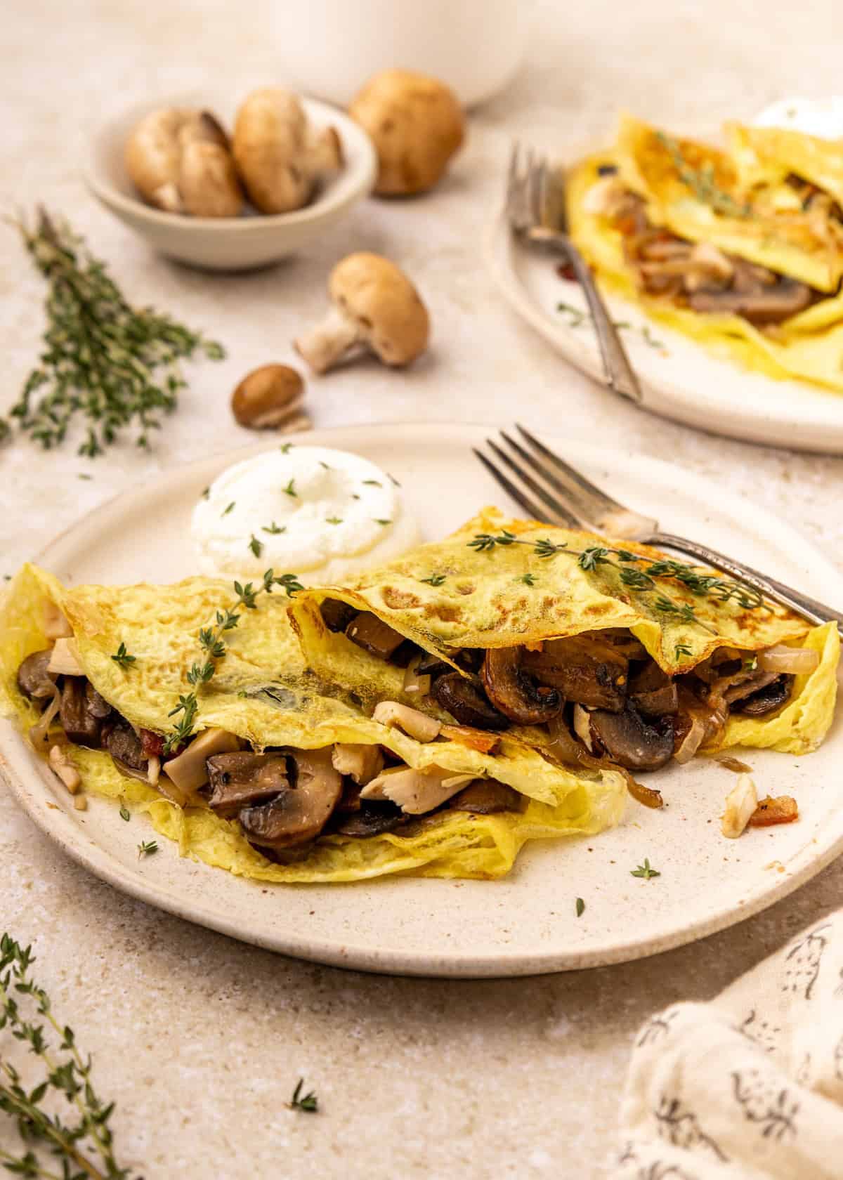 Two omelettes filled with sautéed mushrooms and herbs, like savory chicken mushroom crepes.