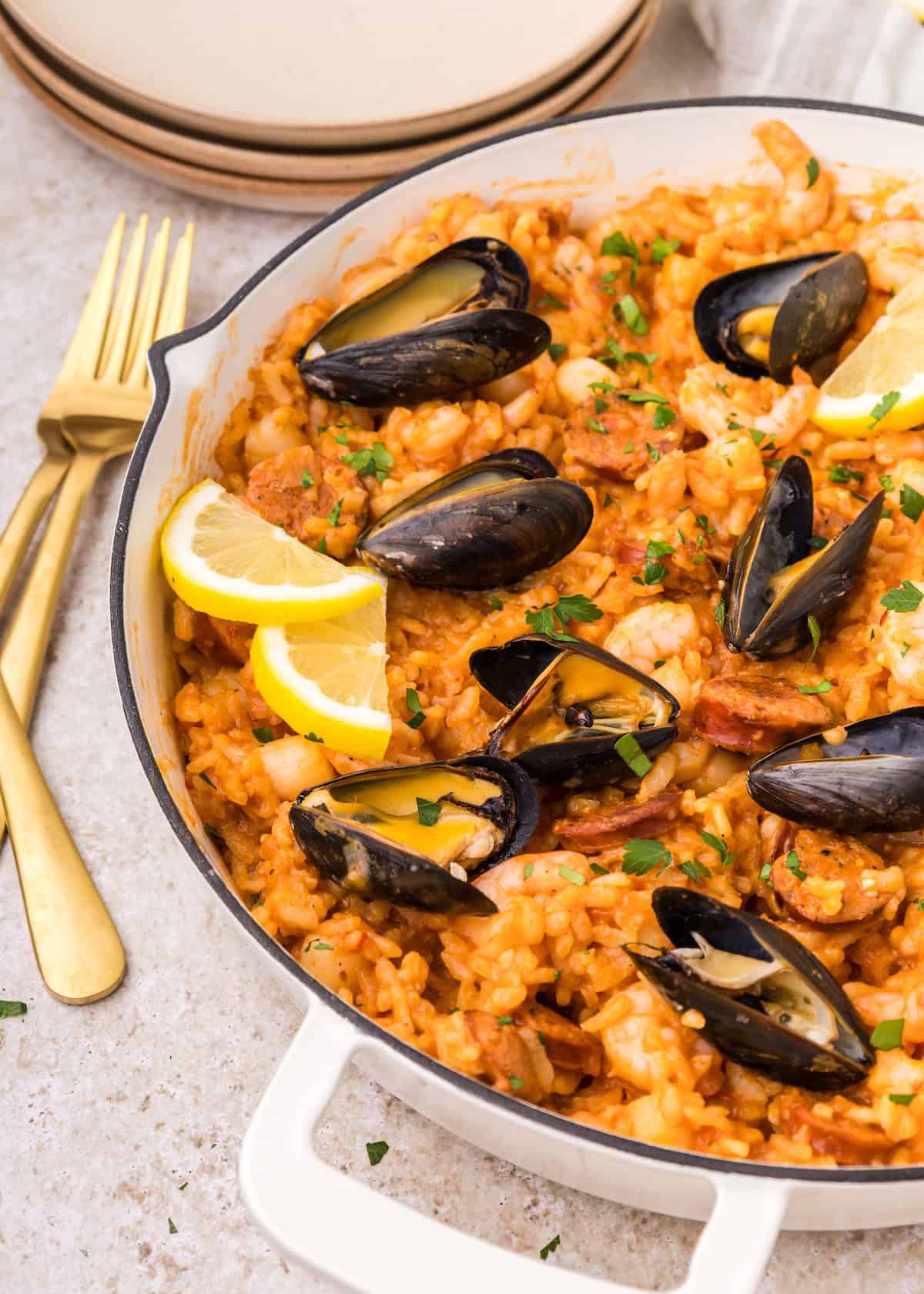 Seafood Paella in a pan with lemon slices.