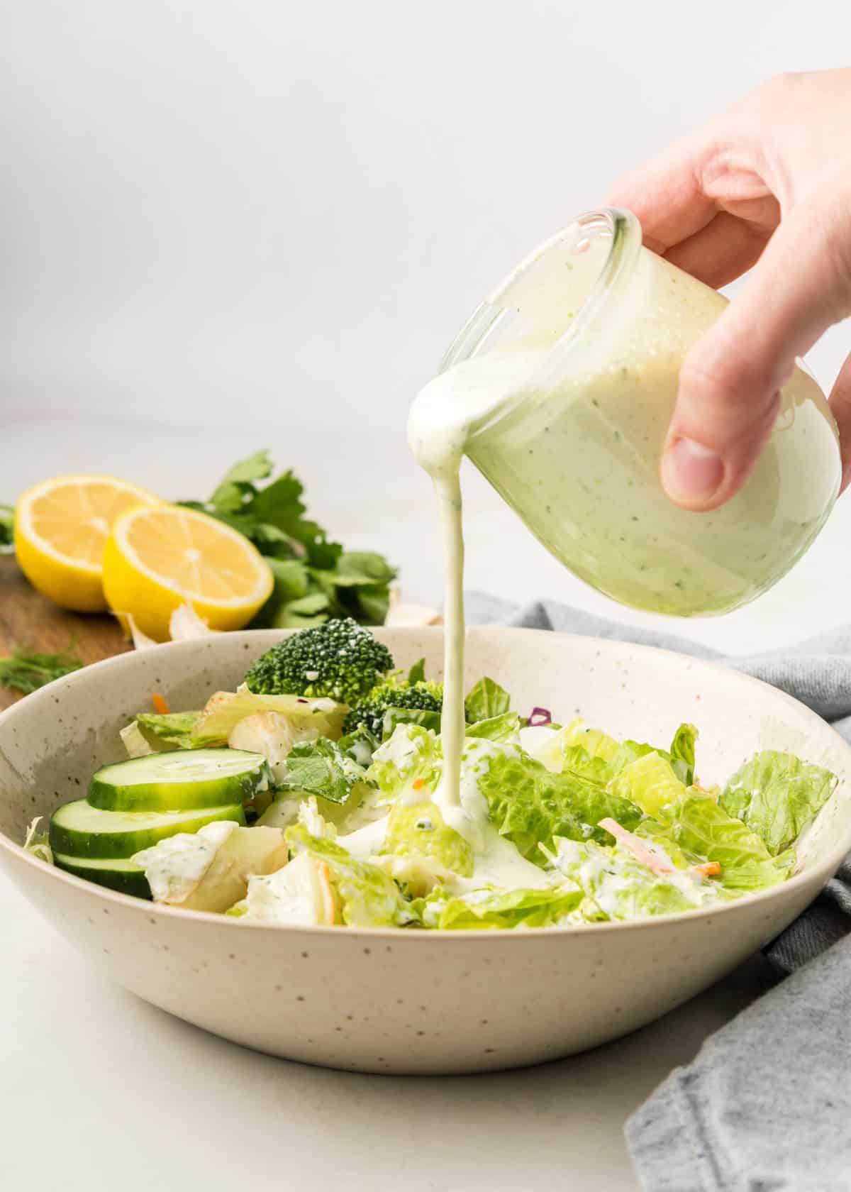 pouring homemade ranch dressing onto salad