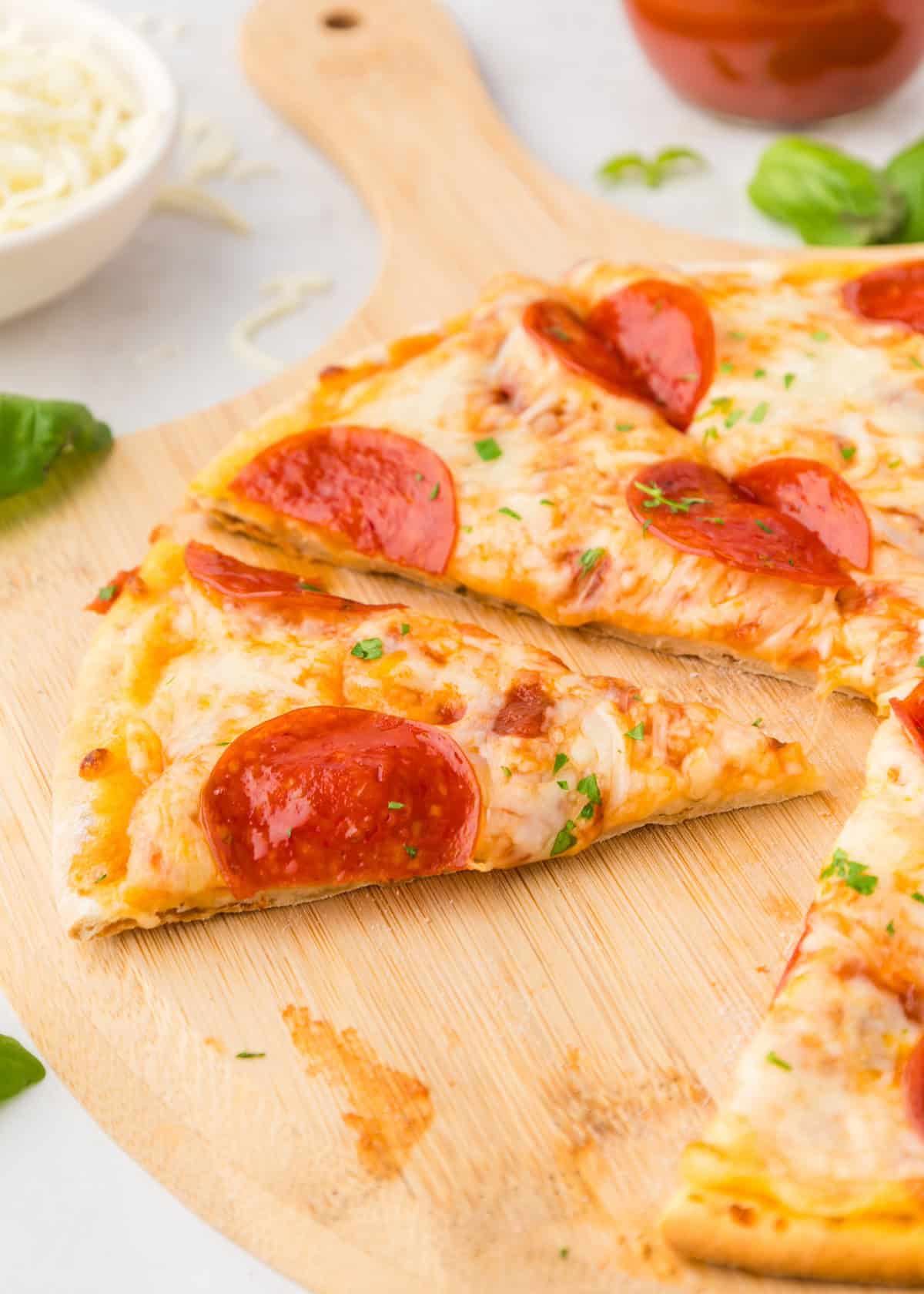 Keto cauliflower pizza on a wooden pizza board.