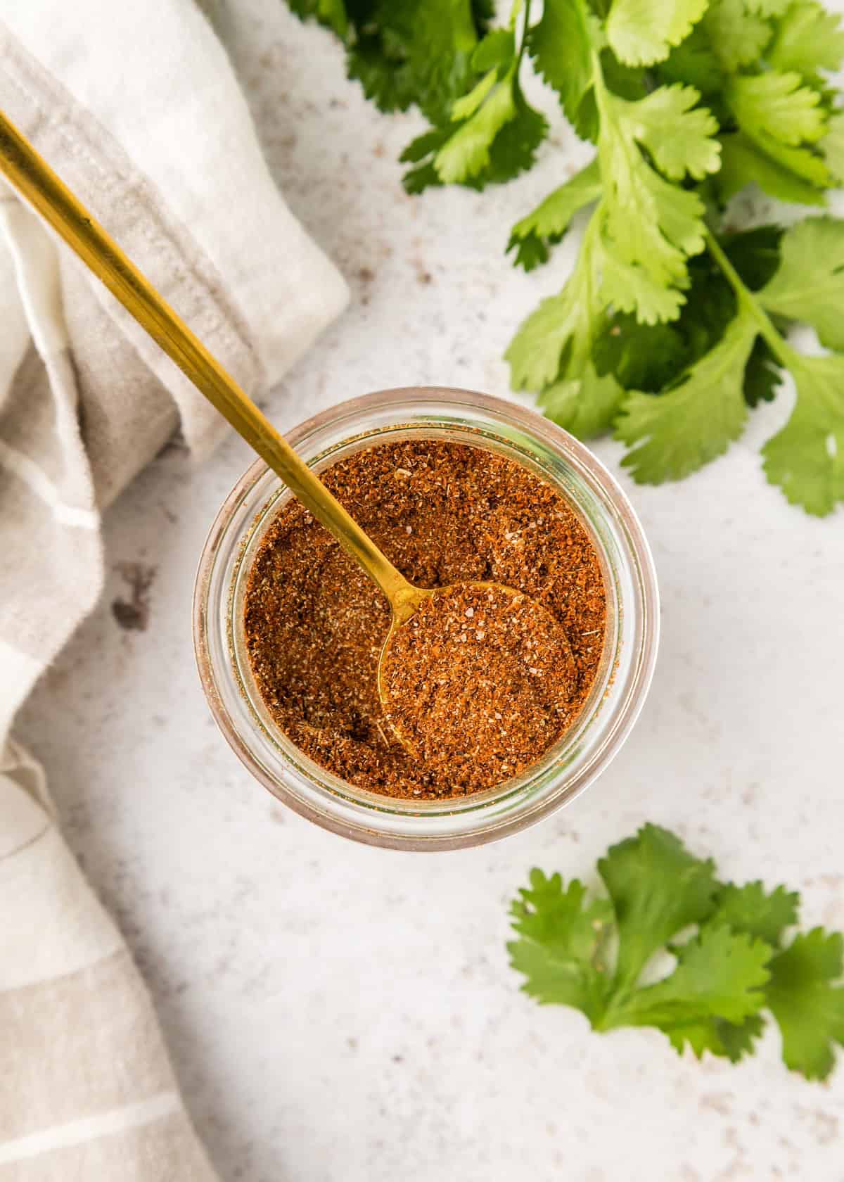 Taco Seasoning in a jar with spoon.