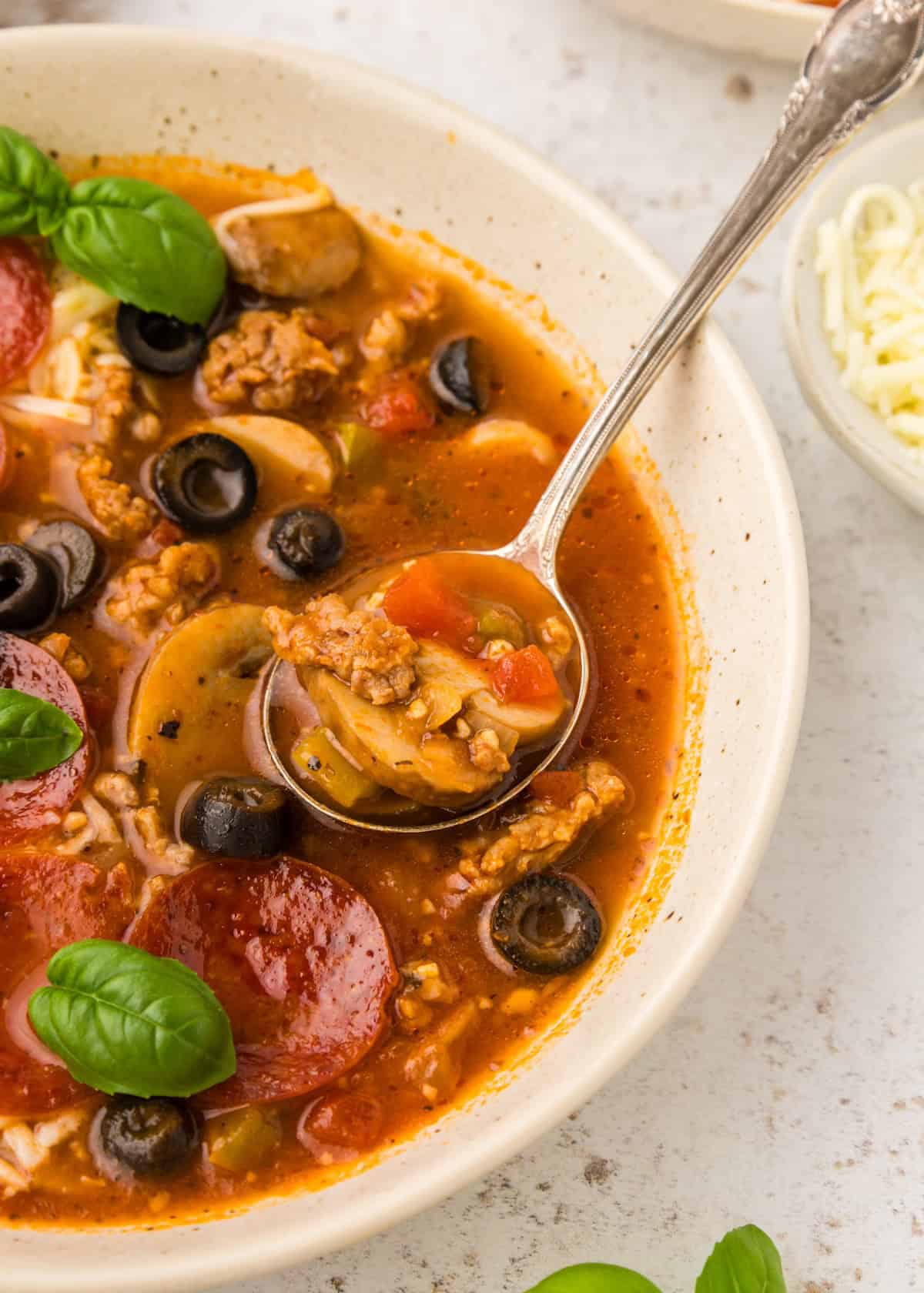 Pizza Soup in a bowl with a spoon.