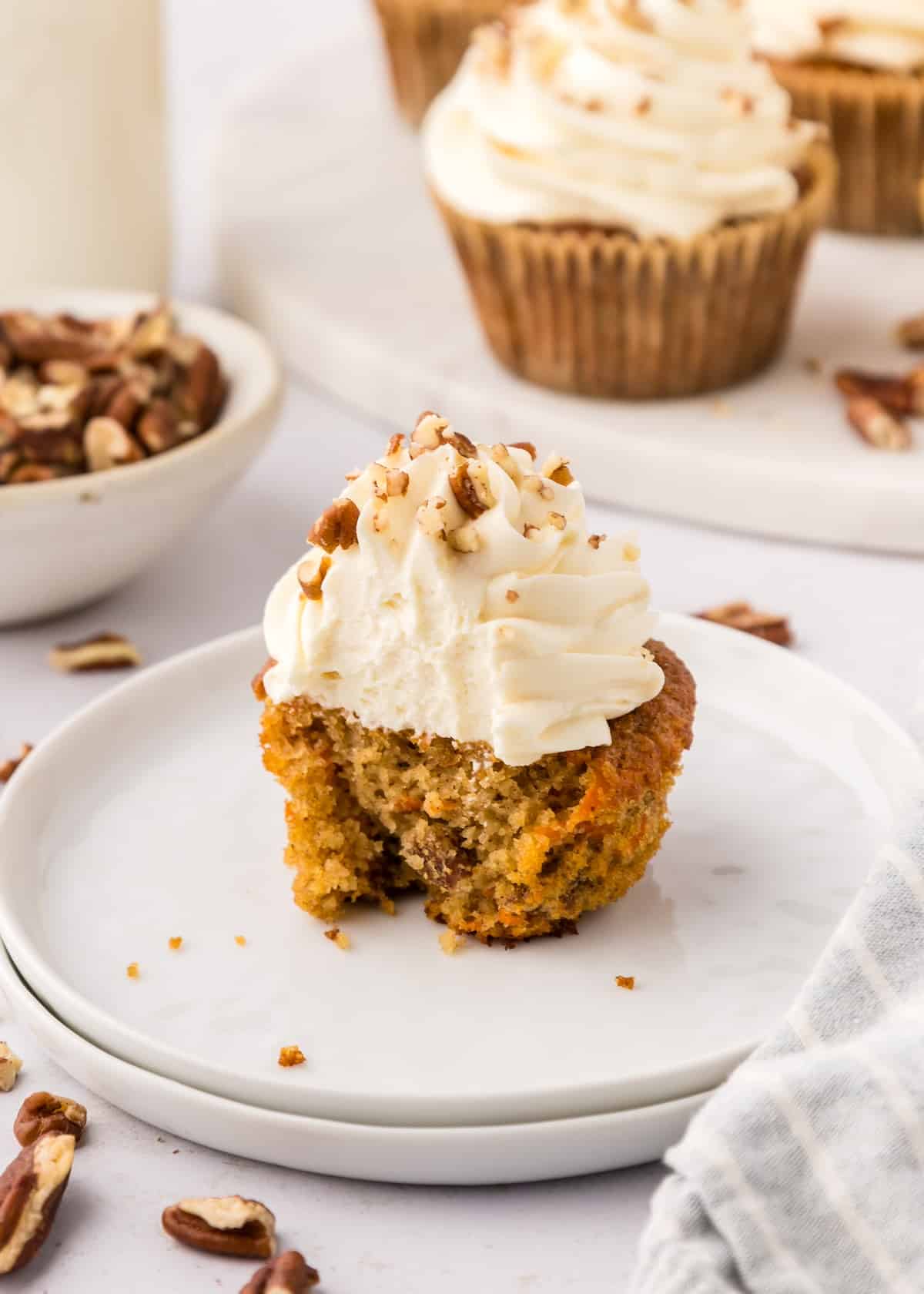 gluten-free carrot cake cupcakes with bite taken out.