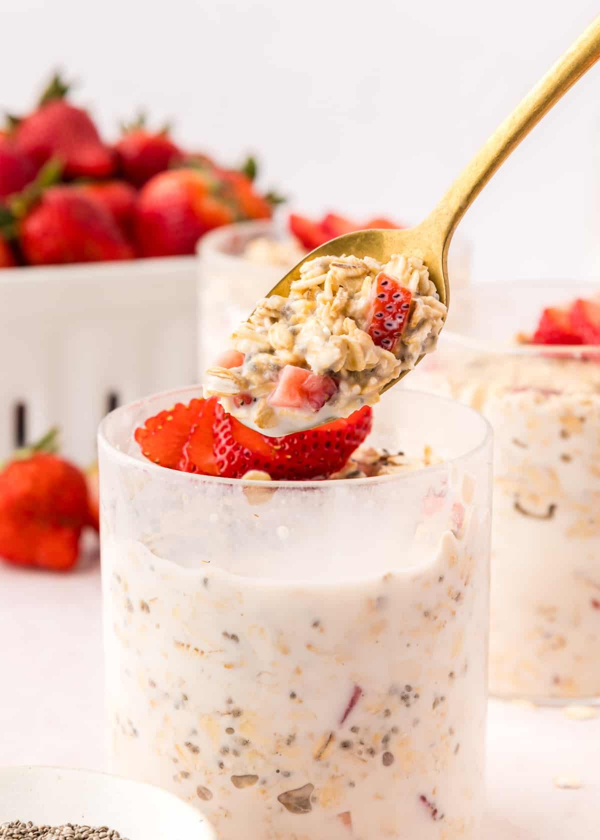strawberry overnight oats with spoon taking out a scoop.