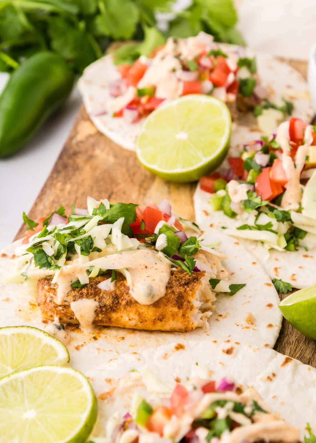 blackened fish tacos with toppings on tortilla
