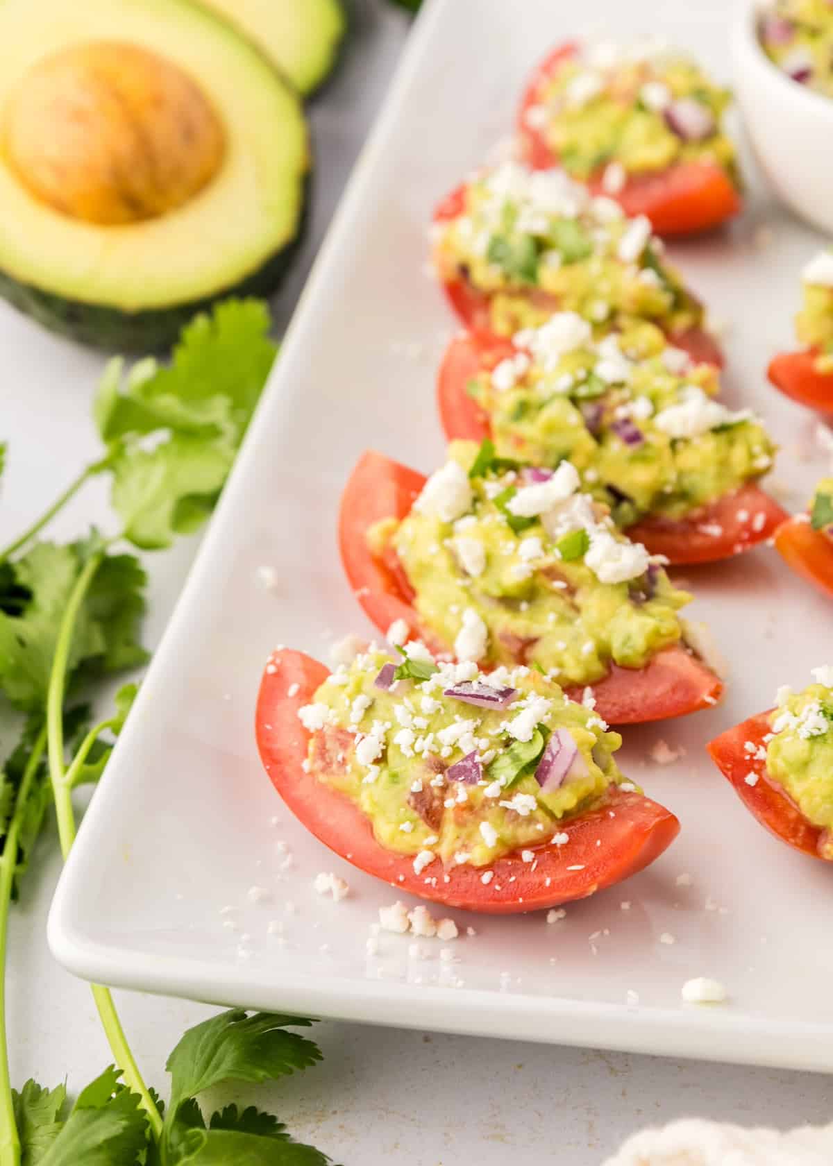 Guacamole bites, tomato slices topped with guacamole.