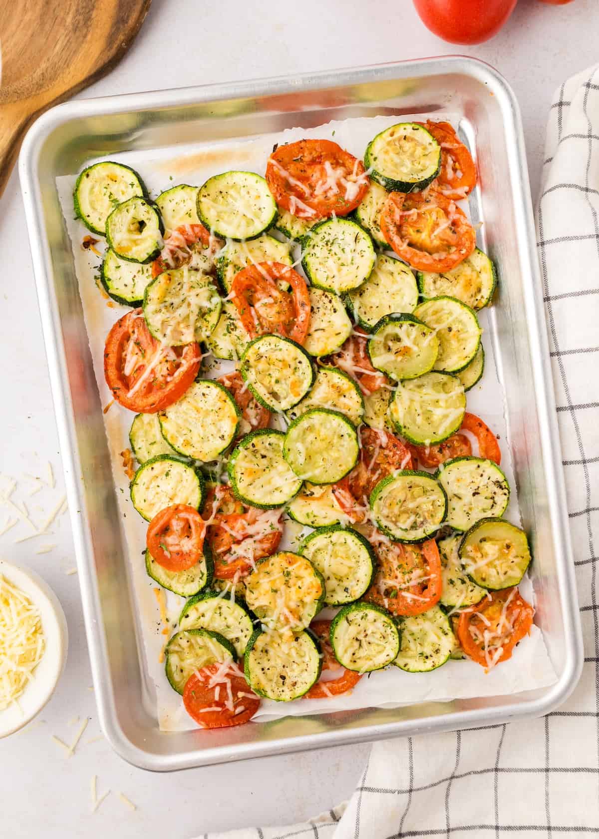 roasted zucchini and tomatoes on baking sheet