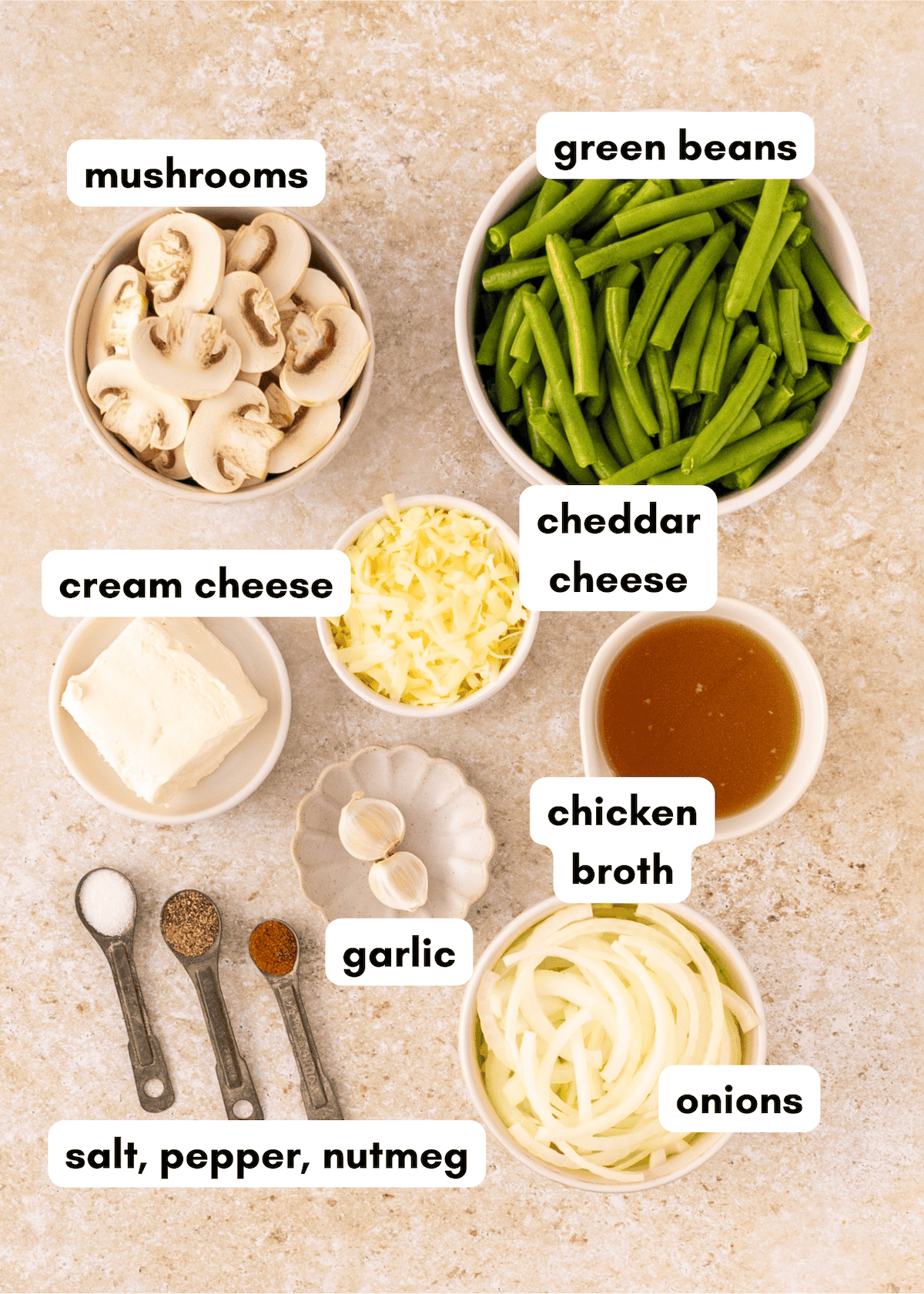 Bowls of mushrooms, cream cheese, cheddar, and spices for Green Bean Casserole creation.