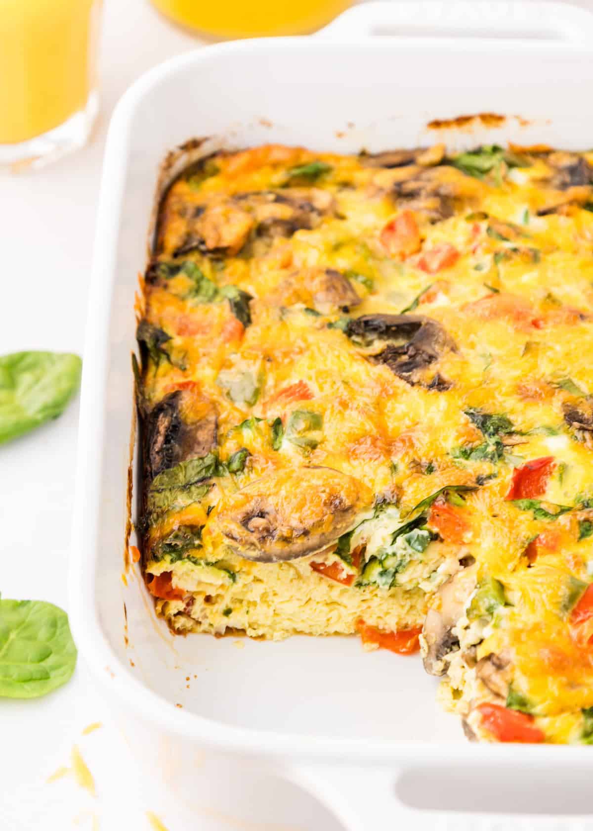 Veggie Breakfast Casserole with veggies and cheese, one square slice removed from the dish.