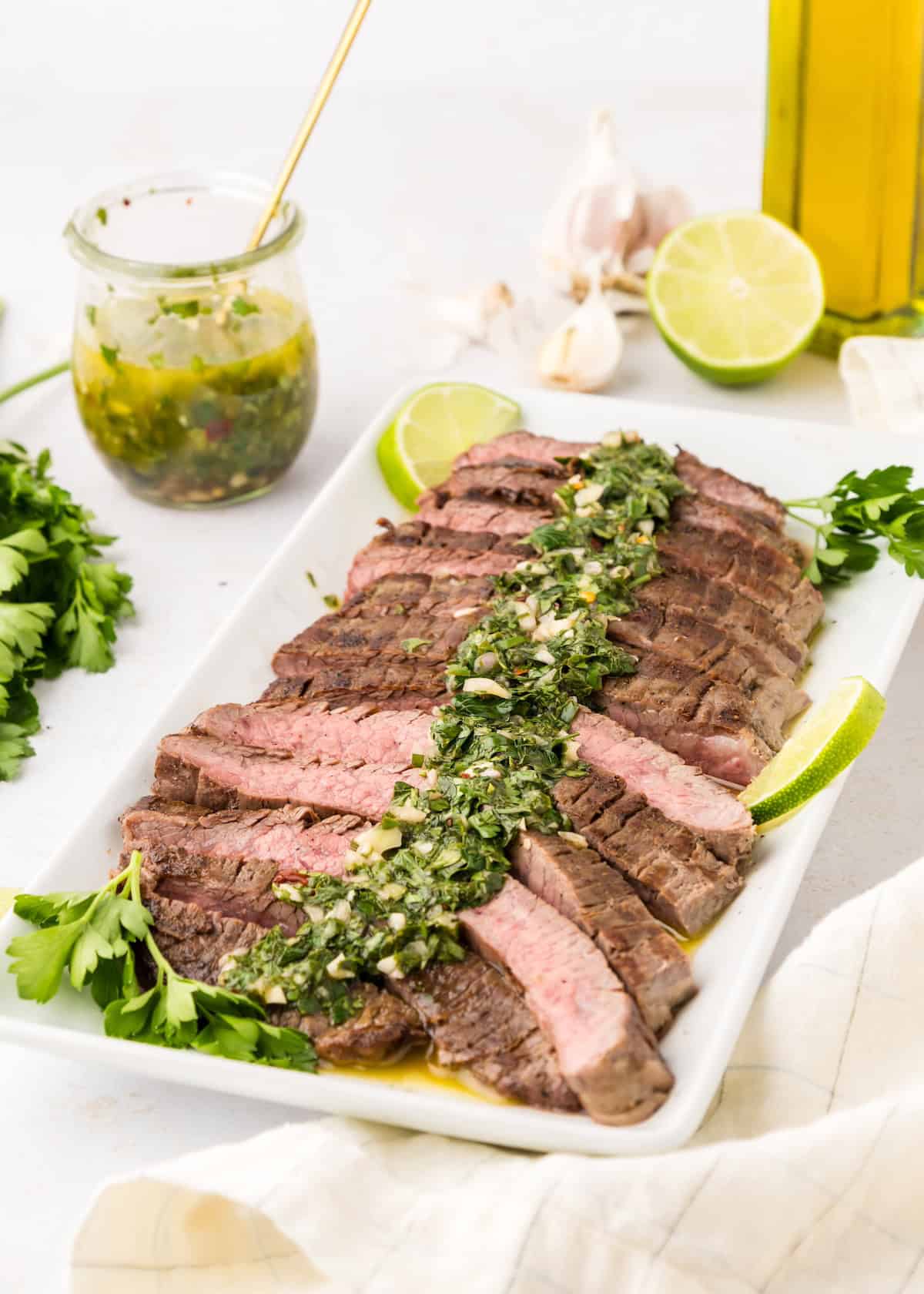Steak topped with chimichurri sauce and served with lime and cilantro.