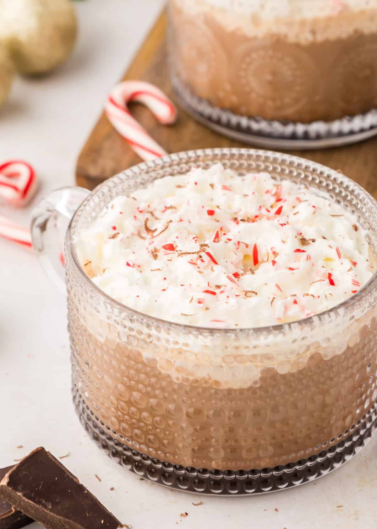 Peppermint mocha in glass mug with crushed candy canes.