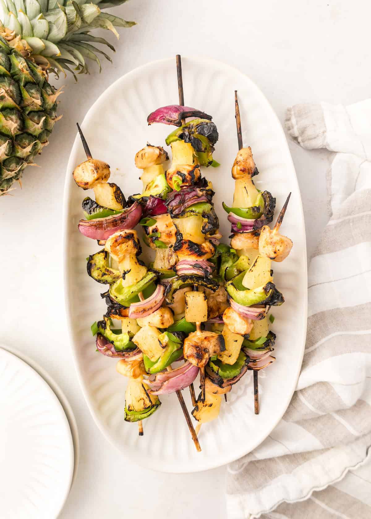 pineapple chicken kabobs, on skewers, on serving platter