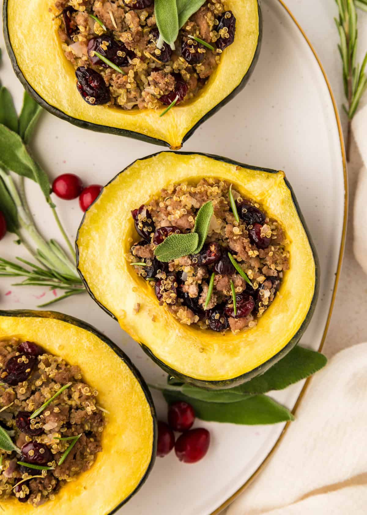 Quinoa Stuffed Acorn Squash with cranberries and herbs served on a white plate.