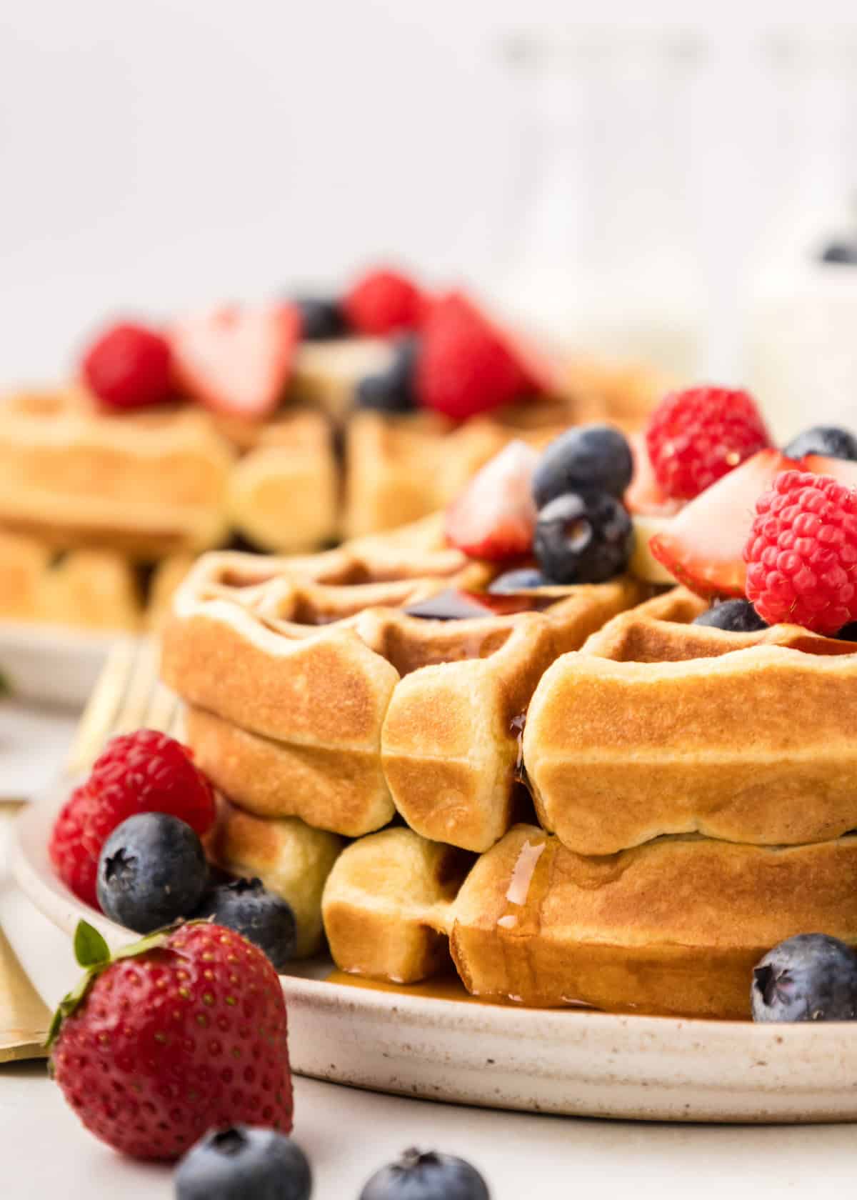 homemade waffles topped with berries and syrup