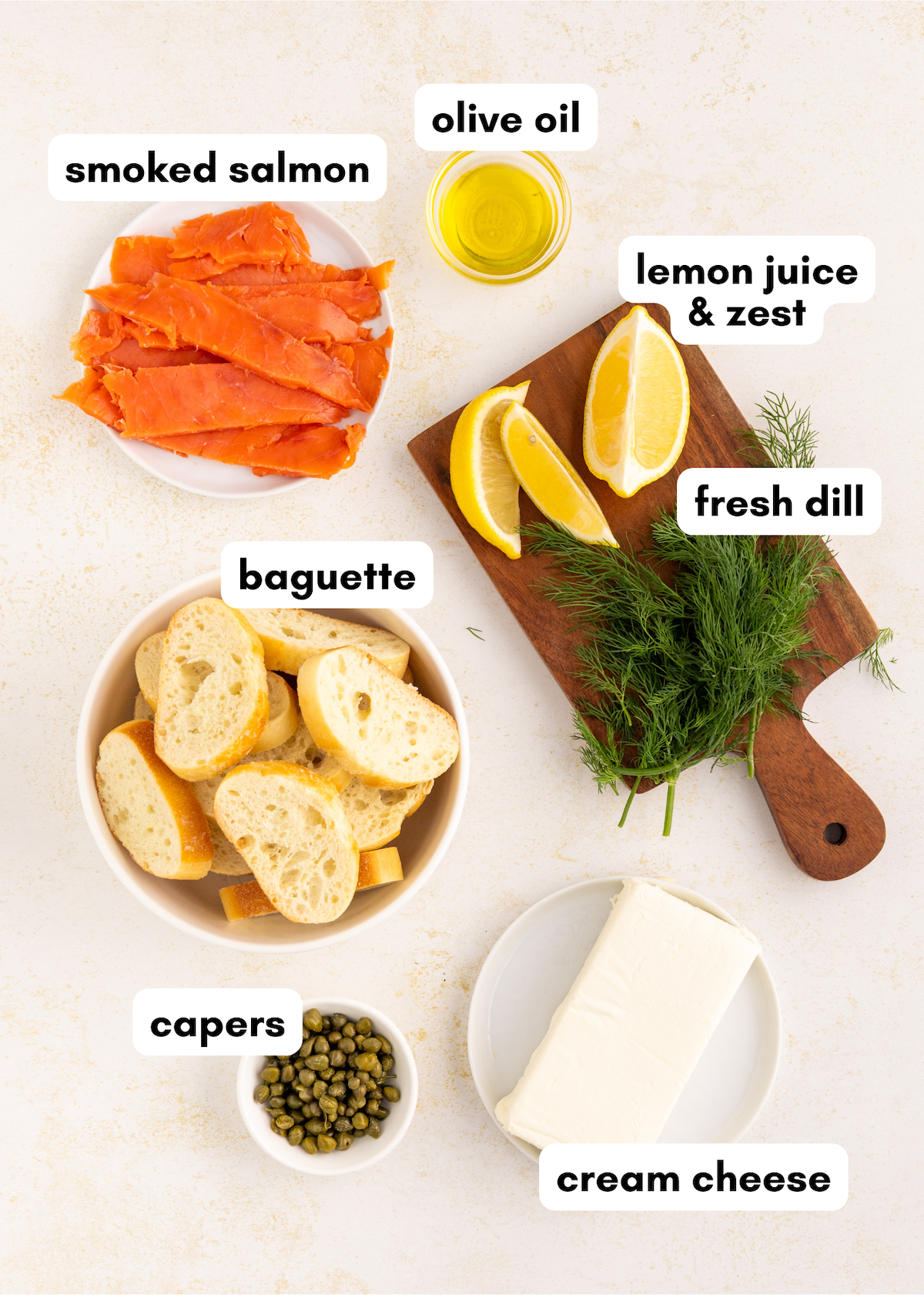 Smoked salmon crostini with cream cheese, capers, dill, lemon, and olive oil on baguette.