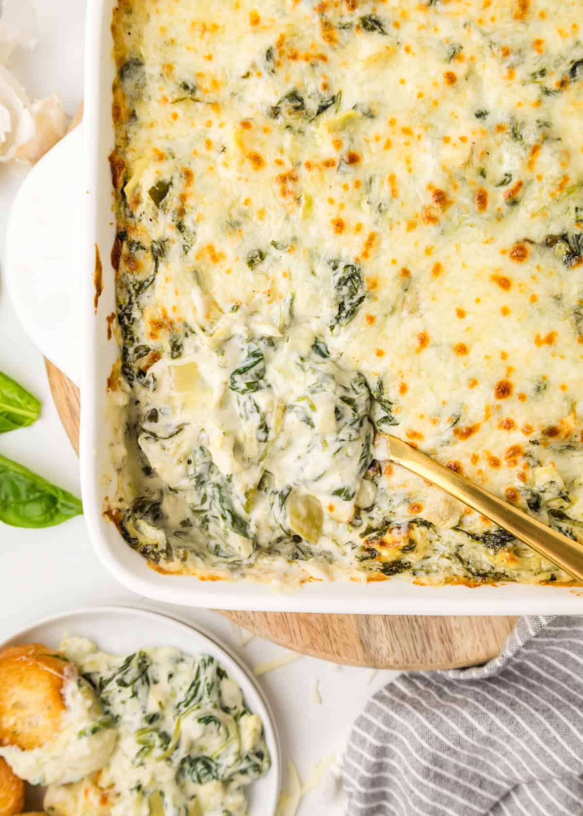 Spinach Artichoke Dip in a baking dish with golden spoon.
