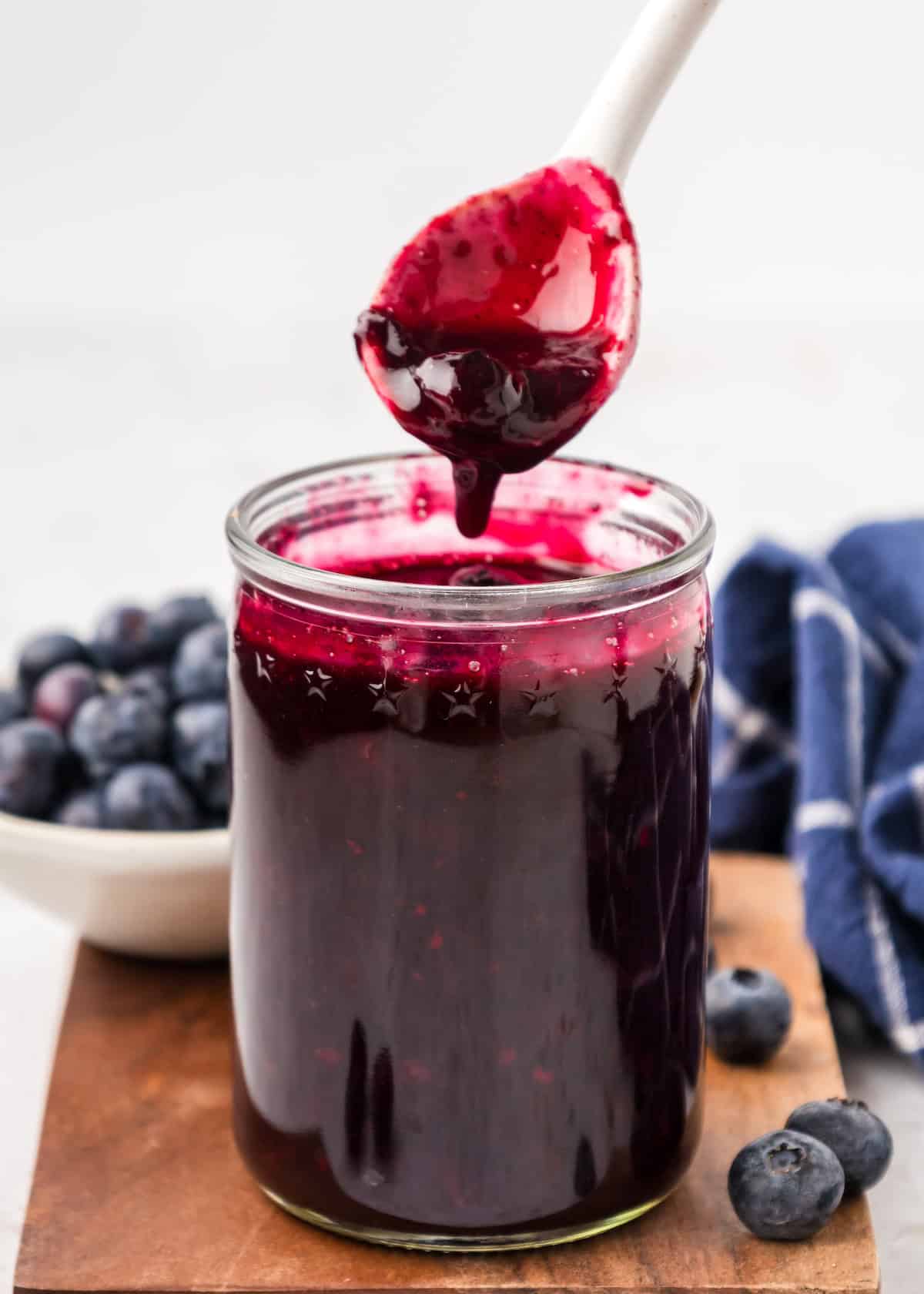 Scooping blueberry compote out of a jar.