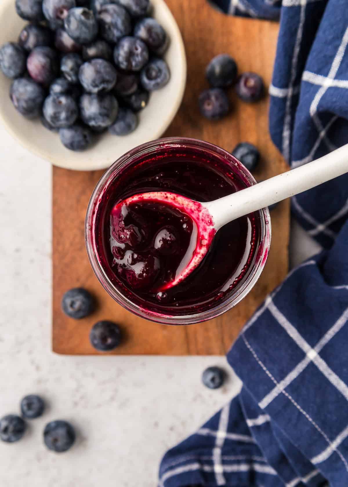 Blueberry Compote in jar with blueberries.