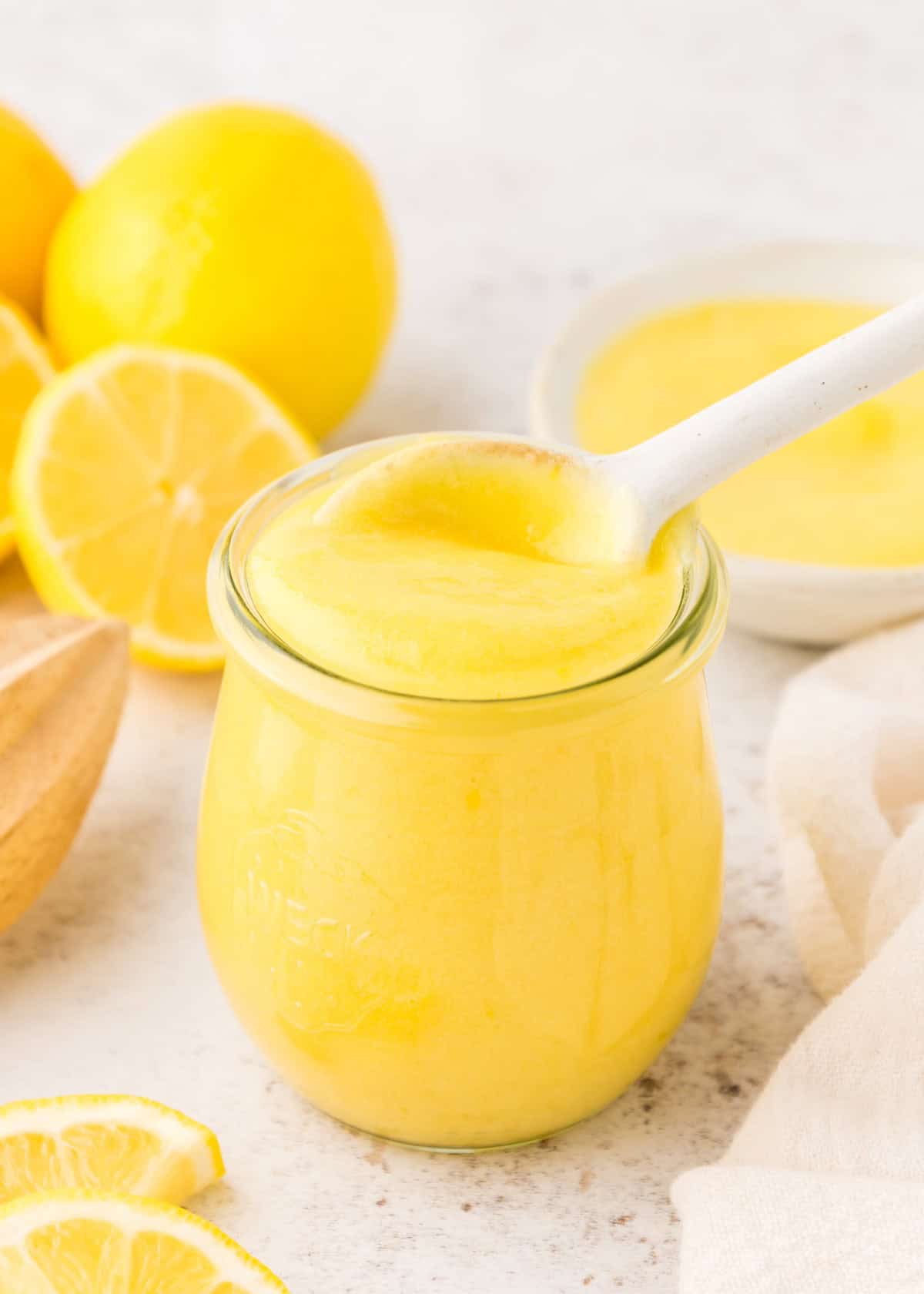 Honey Lemon Curd in a jar with spoon.