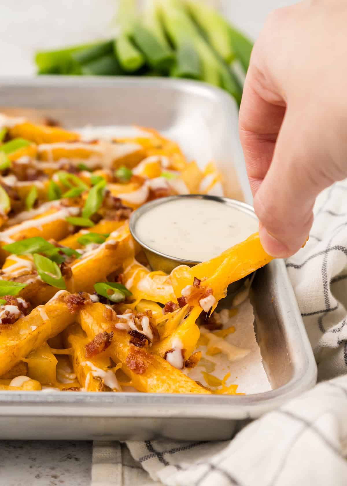 Loaded Cheese Fries lifted showing gooey cheese.