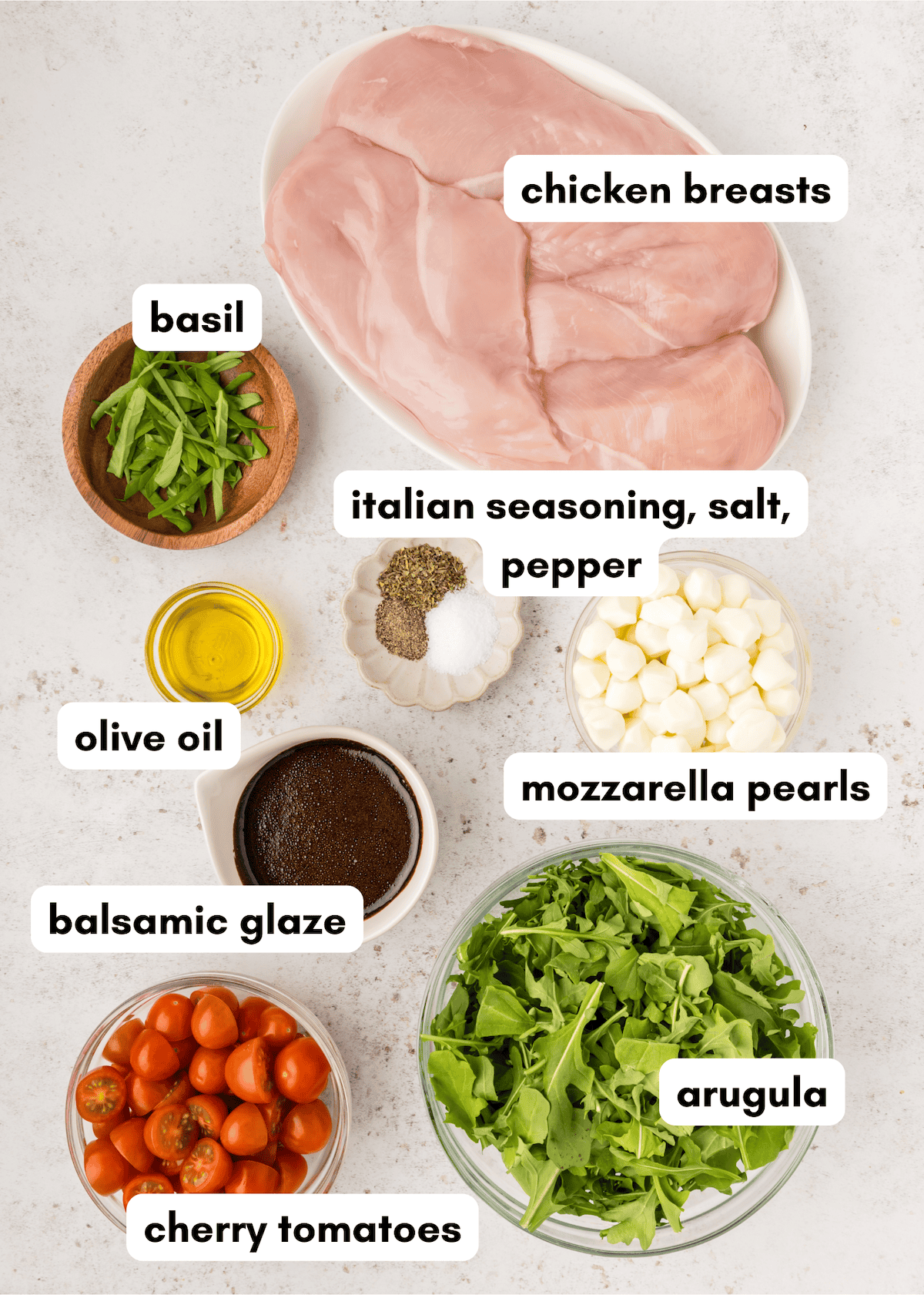 Chicken Caprese Salad with chicken breasts, basil, tomatoes, arugula, mozzarella, and balsamic glaze.