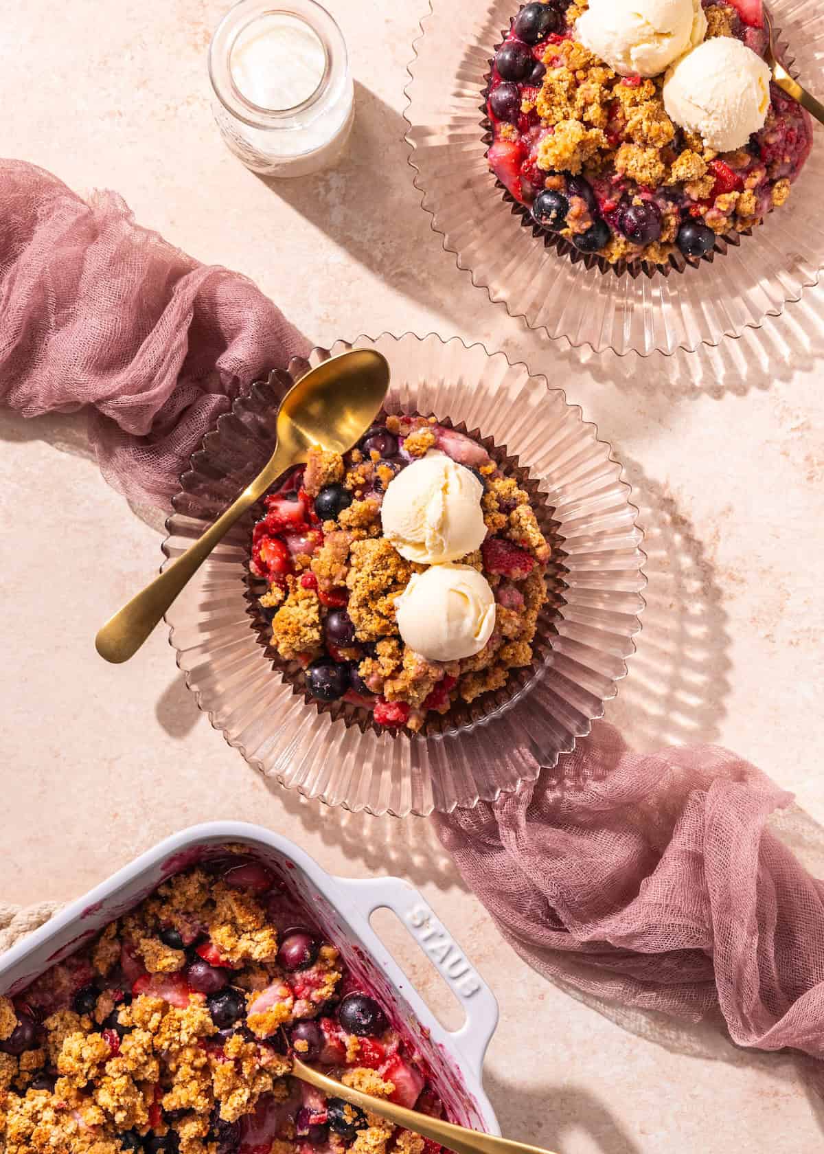 Mixed Berry Cobbler served with ice cream on a pink plate.