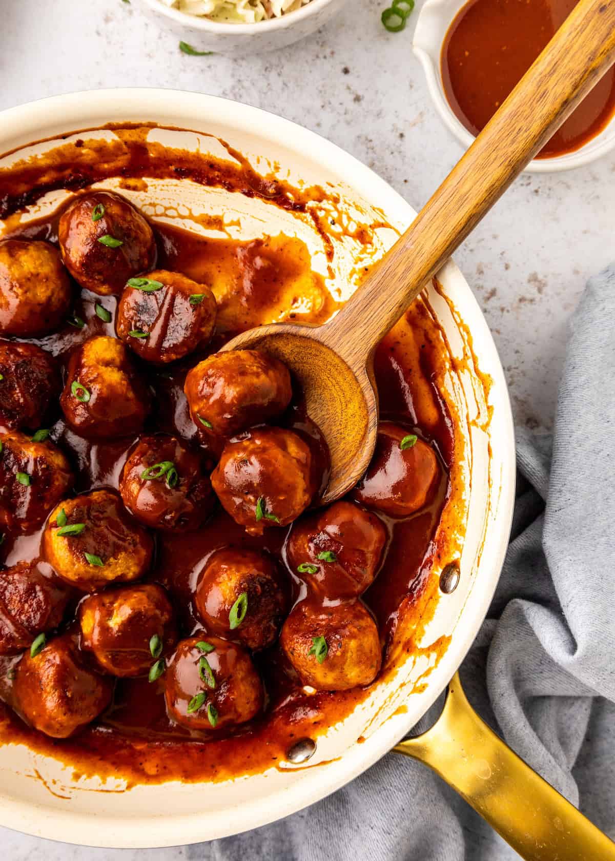 BBQ Chicken Meatballs in a pan with a wooden spoon.