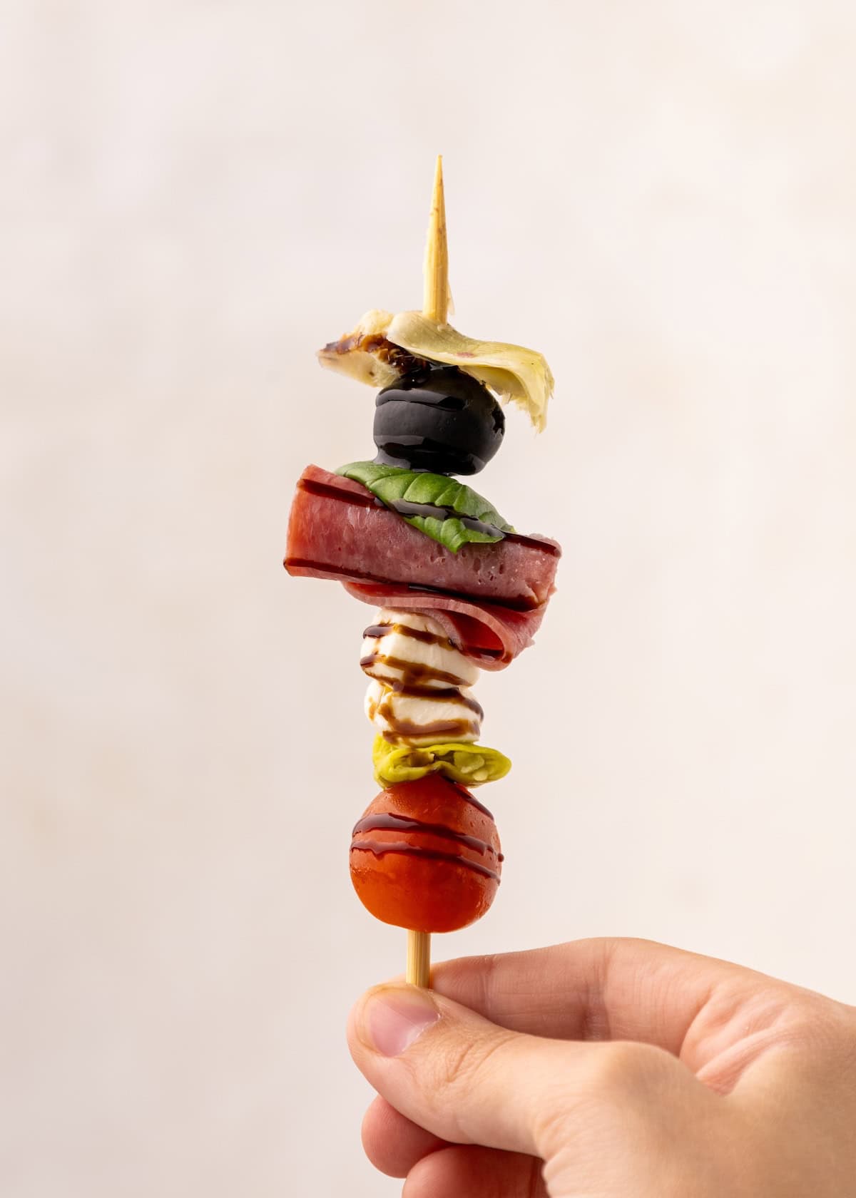 Antipasto Skewer held in a hand.