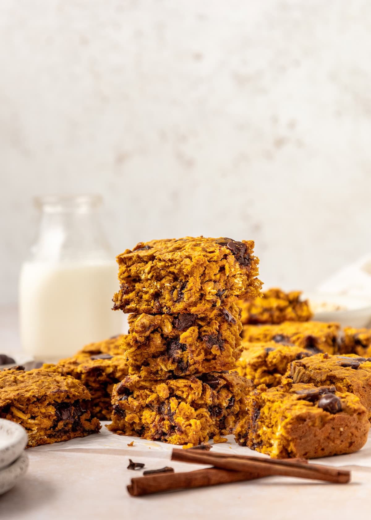 Stacked Pumpkin Bars and cinnamon sticks.