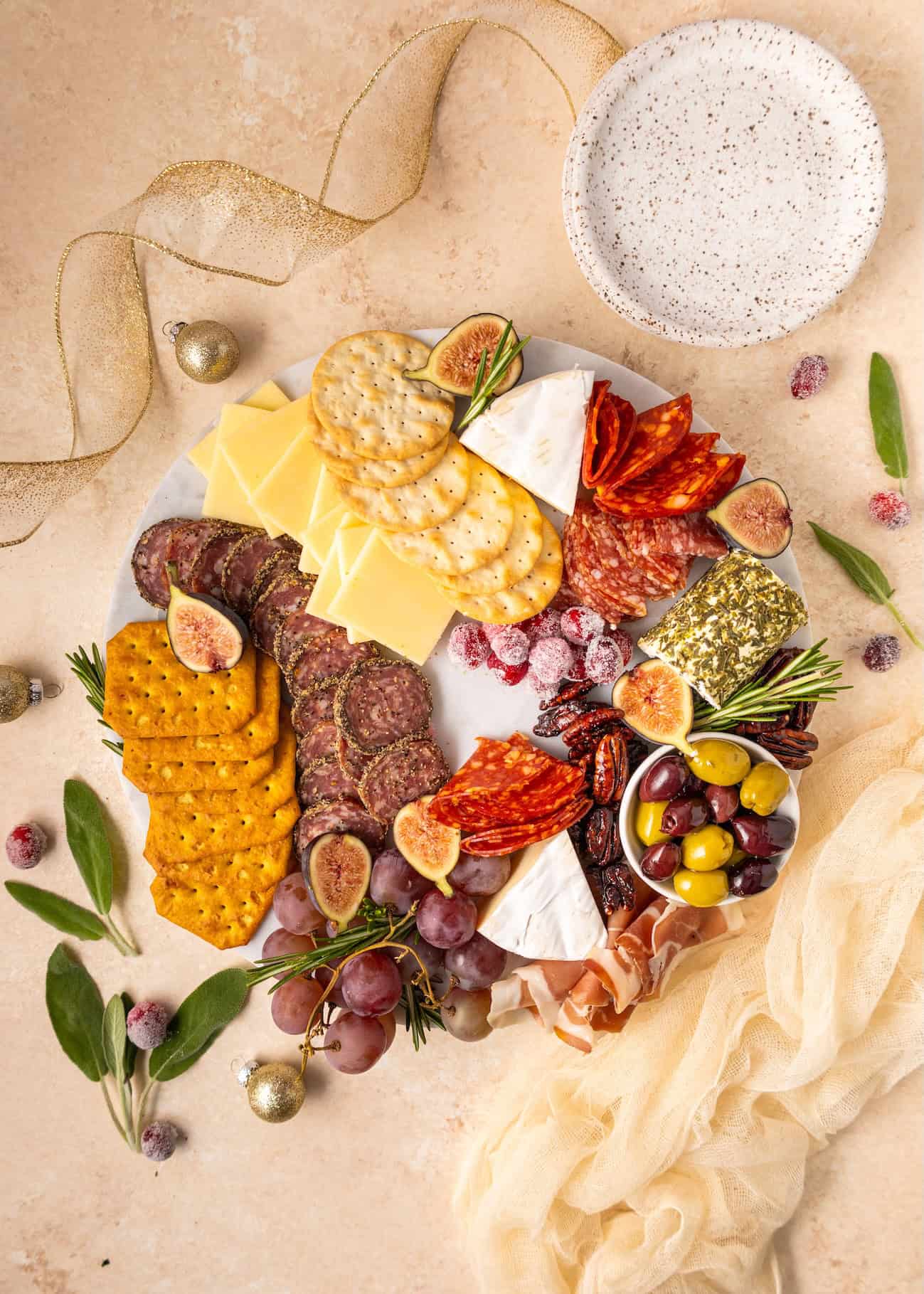 A festive Charcuterie Wreath with meats, cheeses, crackers, fruit, and olives.