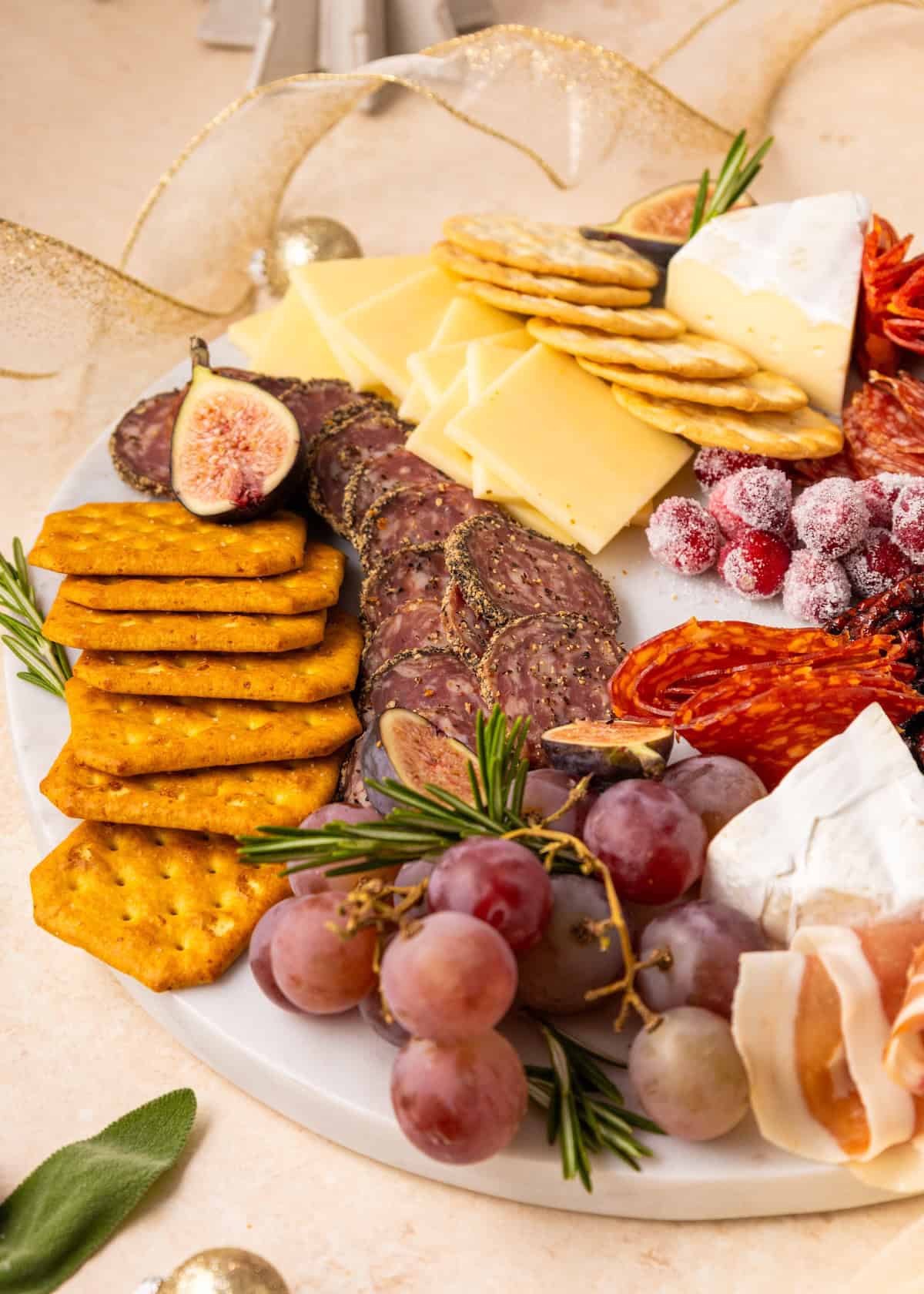 Charcuterie Wreath with crackers, cheese, salami, sugared cranberries, grapes, and figs.