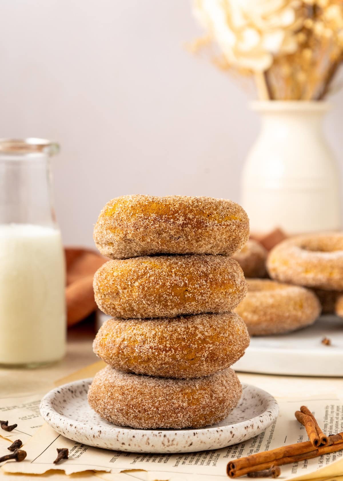 Four stacked pumpkin donuts.