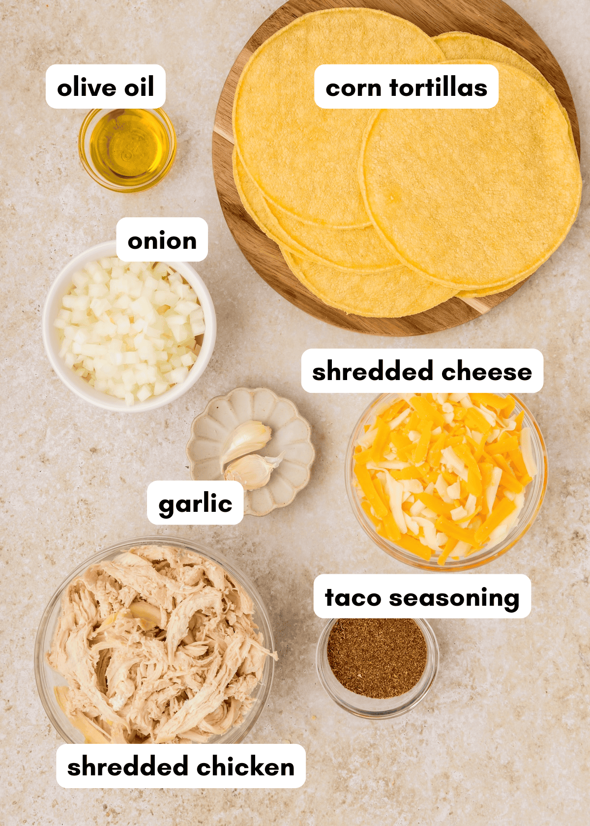 Ingredients for tacos: corn tortillas, olive oil, onion, garlic, shredded cheese, chicken, seasoning.