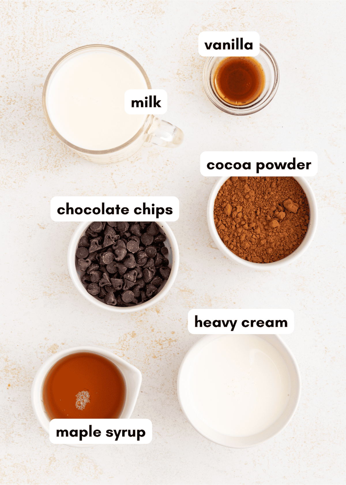 Ingredients for homemade fudgesicles: milk, vanilla, cocoa powder, heavy cream, maple syrup, chocolate chips.