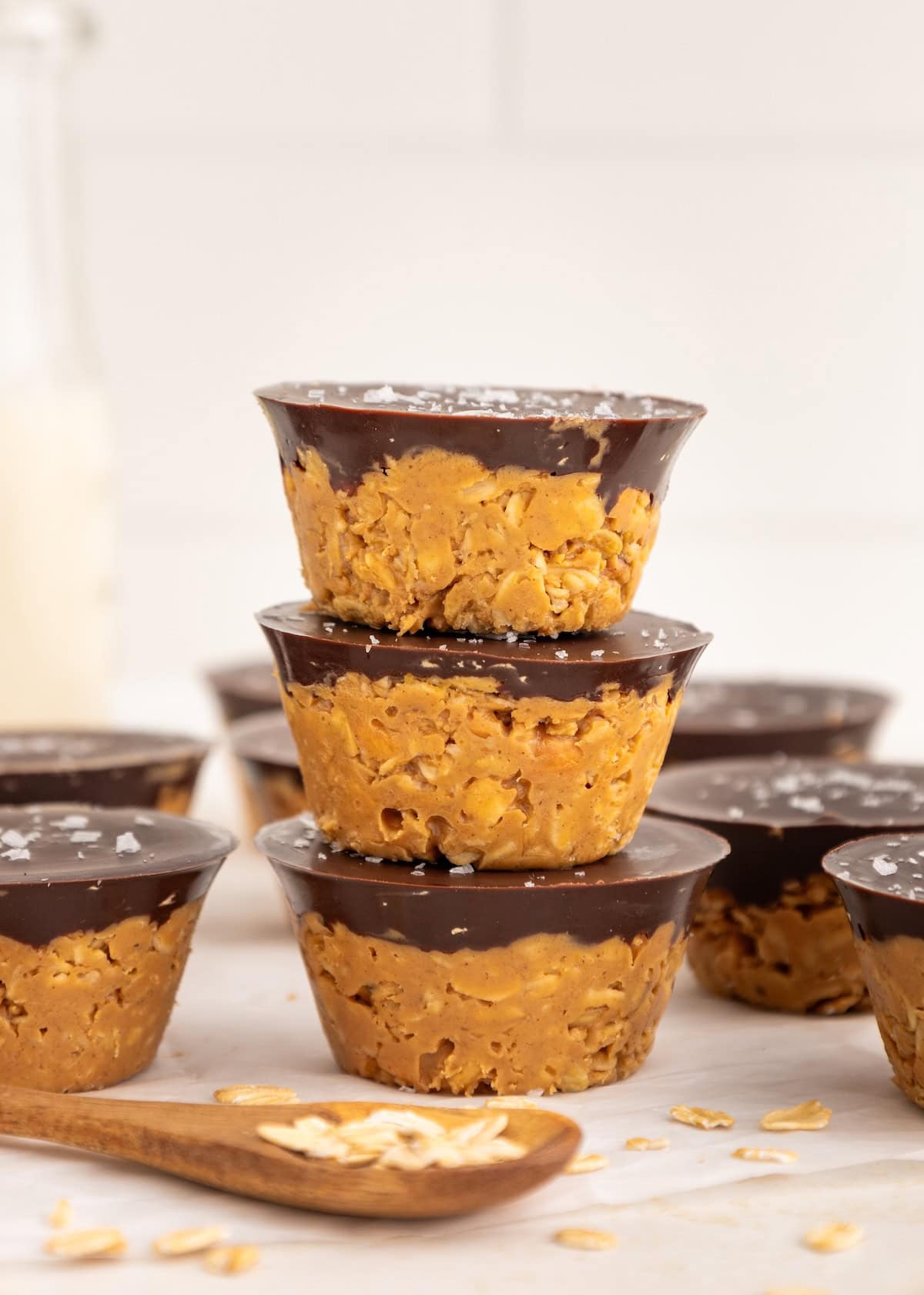 Stacked Peanut Butter Oat Cups topped with rich chocolate and a sprinkle of flaky sea salt.