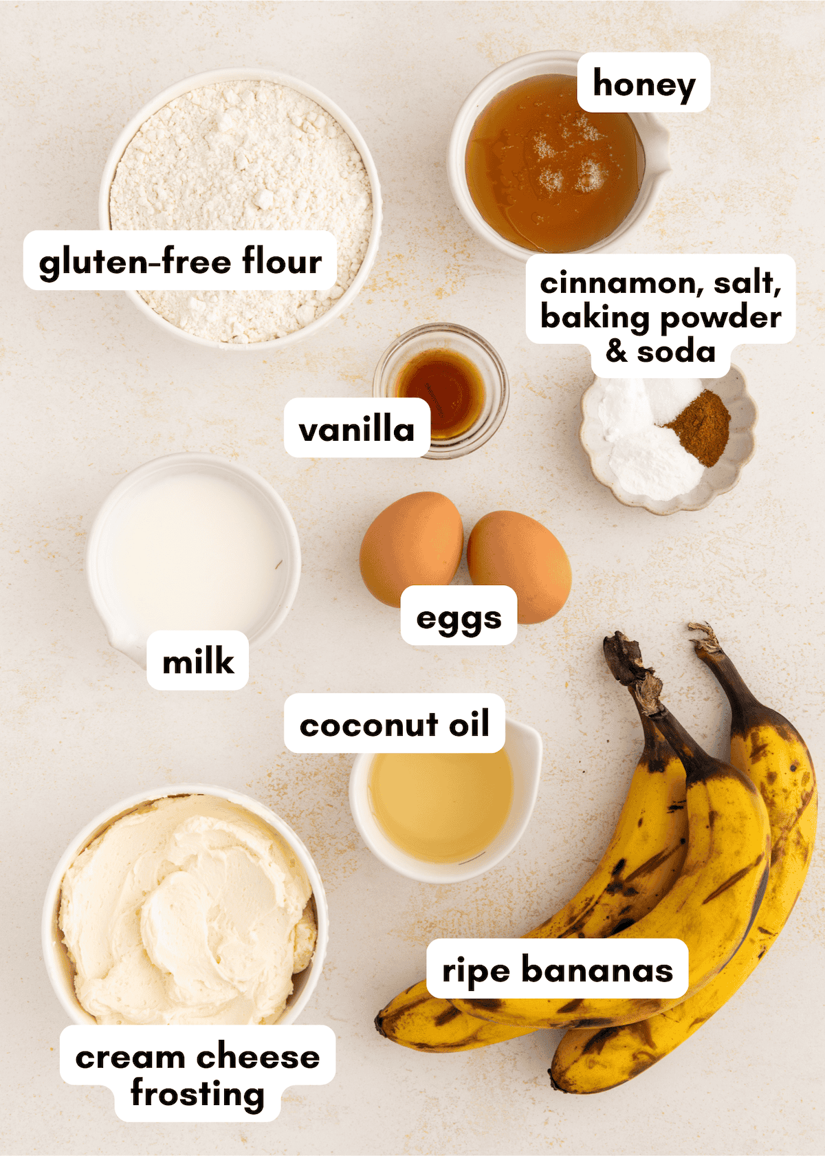 Ingredients for gluten-free banana cake, plus eggs, honey, and cream cheese frosting.